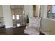 Cozy seating area with a stylish accent chair, mirror, and a glimpse into the kitchen at 1504 Andrew David Ave, North Las Vegas, NV 89086