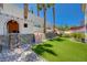 Expansive backyard complete with playhouse, climbing wall, artificial turf, and shady palm trees at 189 Andada Dr, Henderson, NV 89012