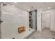 Modern walk-in shower with white tile and a wood bench seat at 189 Andada Dr, Henderson, NV 89012