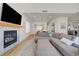 Spacious open-plan living area with a gray sofa, fireplace, and bright natural light at 189 Andada Dr, Henderson, NV 89012