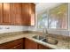 Granite counters accent this bright kitchen featuring wood cabinets and stainless steel sink at 1901 Manhattan Dr, Las Vegas, NV 89106