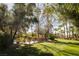 Serene backyard featuring lush green grass, mature trees, and manicured landscaping at 2041 Troon Dr, Henderson, NV 89074