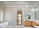 Bright bathroom with marble accents, a soaking tub, and vanity with great lighting at 2041 Troon Dr, Henderson, NV 89074