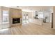 Bright living room with modern fireplace, light wood floors, and seamless access to a white kitchen and backyard views at 2204 Brighton Shore St, Las Vegas, NV 89128
