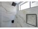 White marbled tiled shower features a black shower head, trim, and soap niche at 2204 Brighton Shore St, Las Vegas, NV 89128