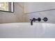 Close-up of a bright bathroom with a white soaking tub and matte black modern faucet at 2204 Brighton Shore St, Las Vegas, NV 89128
