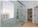 Modern bathroom featuring a large glass shower with marble tiling and a unique glass block window at 2475 Sedona Cedar Ave, Henderson, NV 89052
