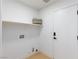 Clean and tidy laundry room with a utility sink, shelving, and a closed door at 2475 Sedona Cedar Ave, Henderson, NV 89052