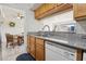 Galley kitchen with stainless steel sink, white dishwasher, and granite countertops leading into a dining room at 2845 Loveland Dr # 3615, Las Vegas, NV 89109