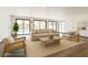 Bright, staged living room featuring neutral furniture, and large windows overlooking the pool area at 2903 Hardin Dr, Henderson, NV 89074