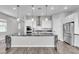 Open kitchen with large island, granite counters, stainless appliances, and hardwood floors at 312 Wind Poppy St, Las Vegas, NV 89138