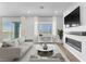 Staged living room featuring a modern fireplace, television, and a view to the outdoors at 312 Wind Poppy St, Las Vegas, NV 89138