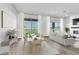 Bright, staged living room with a dining set, modern furniture, fireplace and sliding glass doors at 312 Wind Poppy St, Las Vegas, NV 89138