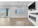 Open living room with sliding glass doors, modern fireplace and wood flooring at 312 Wind Poppy St, Las Vegas, NV 89138