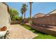 Backyard patio features brick pavers, synthetic grass, and tall palm trees at the back wall at 3597 Cherbourg Ave, Las Vegas, NV 89141