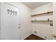 Laundry room area with shelving for storage and hook designs on the entryway door at 3597 Cherbourg Ave, Las Vegas, NV 89141