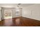 Bright living room with hardwood floors, ceiling fan, sliding glass door to backyard, and archway features at 3597 Cherbourg Ave, Las Vegas, NV 89141