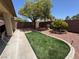 Private backyard with artificial turf and desert landscaping at 3720 Tack St, Las Vegas, NV 89122