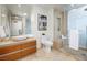 Modern bathroom with a vessel sink, travertine tile and a glass enclosed shower with a built in bench at 3722 Las Vegas Blvd # 2512 E, Las Vegas, NV 89158