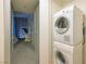 A well lit laundry closet with a stackable washer and dryer, with doorway to bedroom and city views at 3722 Las Vegas Blvd # 2512 E, Las Vegas, NV 89158