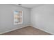 Bright bedroom featuring neutral walls and carpet, with a window offering natural light at 390 Clarence House Ave # 1, North Las Vegas, NV 89032