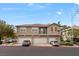 Three-story townhome with a tan exterior, red tile roof and three garages in a well maintained community at 390 Clarence House Ave # 1, North Las Vegas, NV 89032