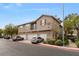 Three-story townhome with a tan exterior, red tile roof and three garages in a well maintained community at 390 Clarence House Ave # 1, North Las Vegas, NV 89032