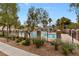 Well-maintained community pool surrounded by lush landscaping and a wrought iron fence at 390 Clarence House Ave # 1, North Las Vegas, NV 89032