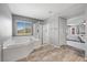 Relaxing bathroom with a large soaking tub, separate glass enclosed shower, and tile flooring at 4021 Mountain Trek St, Las Vegas, NV 89129
