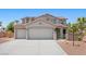 Two-story home featuring a tile roof, solar panels, attached three-car garage, and desert landscaping at 4021 Mountain Trek St, Las Vegas, NV 89129