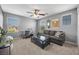 Cozy living room with a ceiling fan, neutral carpet, a grey sofa, and natural light at 4021 Mountain Trek St, Las Vegas, NV 89129
