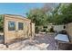 Cozy backyard with a shed, brick patio, seating areas, and mature trees at 4027 Maple Hill Rd, Las Vegas, NV 89115
