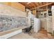 Open basement area featuring unique stone walls, exposed ceiling, and tiled floor at 4027 Maple Hill Rd, Las Vegas, NV 89115