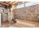 Finished basement area with exposed wood ceiling and decorative stone wall at 4027 Maple Hill Rd, Las Vegas, NV 89115