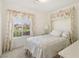 Charming bedroom with floral curtains, a patterned comforter, and bright natural light at 4027 Maple Hill Rd, Las Vegas, NV 89115