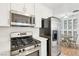 Kitchen showcasing stainless steel appliances, white cabinets, and a cozy dining area at 4027 Maple Hill Rd, Las Vegas, NV 89115