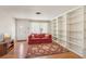 Bright living room featuring hardwood floors, built-in bookshelves, a decorative rug, and front door access at 4027 Maple Hill Rd, Las Vegas, NV 89115