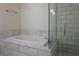 A luxurious soaking tub and glass-enclosed shower with modern fixtures and elegant tiling at 4471 Dean Martin Dr # 2406, Las Vegas, NV 89103