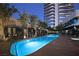 Large pool with modern cabanas, manicured trees, and high-rise residential tower in the background at 4471 Dean Martin Dr # 2406, Las Vegas, NV 89103