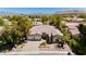 Aerial view of home with lush landscaping, mature trees, and a circular driveway at 4493 Rometta Ave, Las Vegas, NV 89141