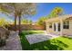 Nicely landscaped backyard with artificial turf, desert landscaping, patio, and putting green at 4493 Rometta Ave, Las Vegas, NV 89141