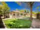 View of backyard putting green with desert landscaping, pergola, and block wall at 4493 Rometta Ave, Las Vegas, NV 89141
