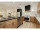 Bright kitchen with stainless steel appliances, wooden cabinets, and a black kitchen island at 4493 Rometta Ave, Las Vegas, NV 89141