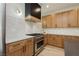 Stylish kitchen features stainless steel stove, modern range hood, and white countertop and backsplash at 4493 Rometta Ave, Las Vegas, NV 89141