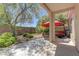 A backyard patio under a covered awning with a lawn, plants and stone wall at 4672 Regalo Bello St, Las Vegas, NV 89135