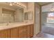 Bright bathroom with double sinks, tile floors, a large mirror and nice lighting at 4672 Regalo Bello St, Las Vegas, NV 89135