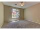 Bright bedroom with carpeting, ceiling fan, and a large window allowing natural light at 4672 Regalo Bello St, Las Vegas, NV 89135