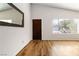 Bright living room showcases wood floors, a dark wood door and large window with natural light at 4775 Woodridge Rd, Las Vegas, NV 89121