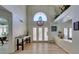 Grand foyer with a vaulted ceiling, chandelier, and bright light from the french doors at 5133 Southern Hills Ln, Las Vegas, NV 89113