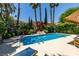 Gorgeous backyard pool area featuring lush landscaping, including palm trees, and comfortable lounge chairs at 5133 Southern Hills Ln, Las Vegas, NV 89113